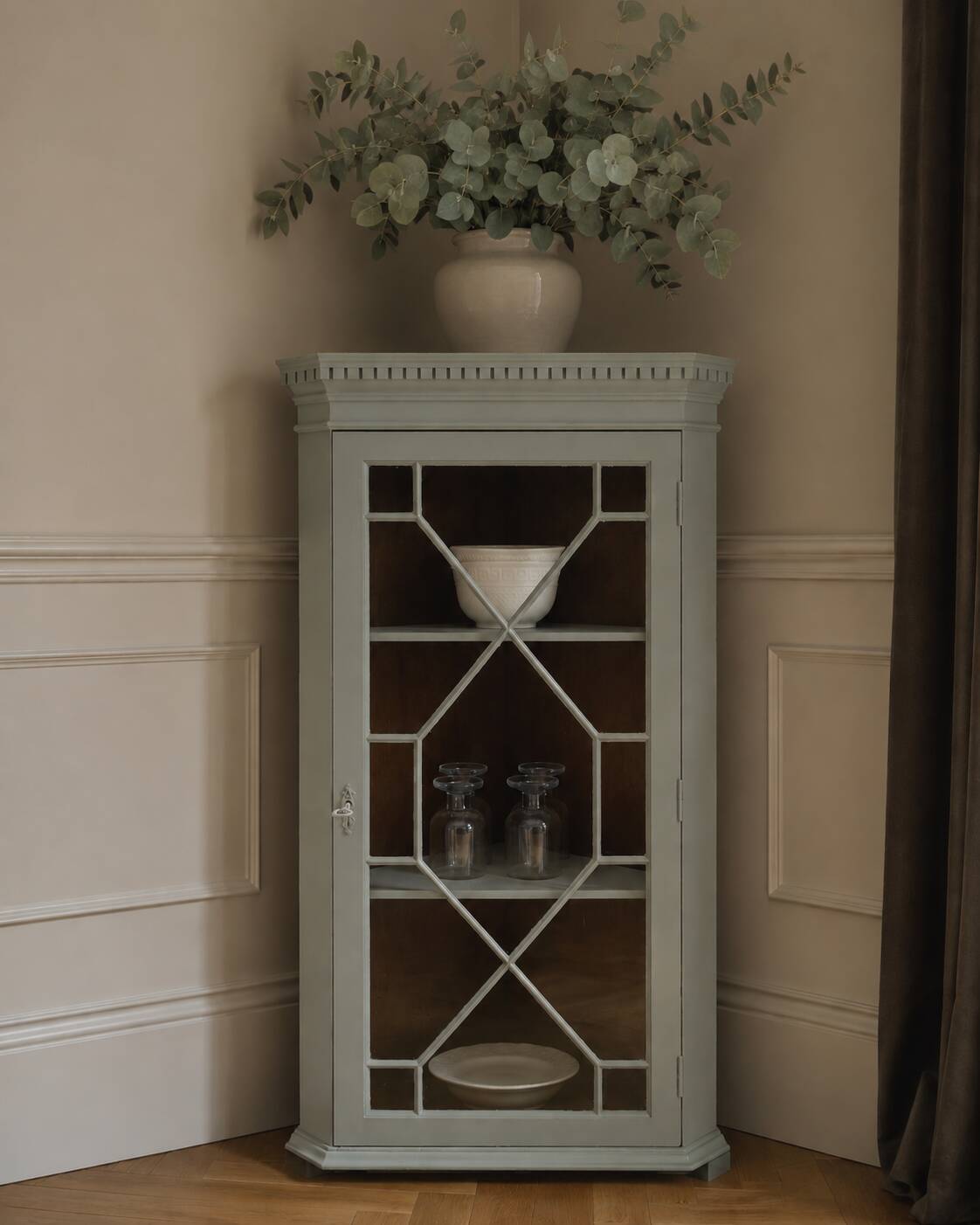 Vintage English corner display cabinet enhanced in grey-green with a wooden top.