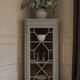 Vintage English corner display cabinet enhanced in grey-green with a wooden top.