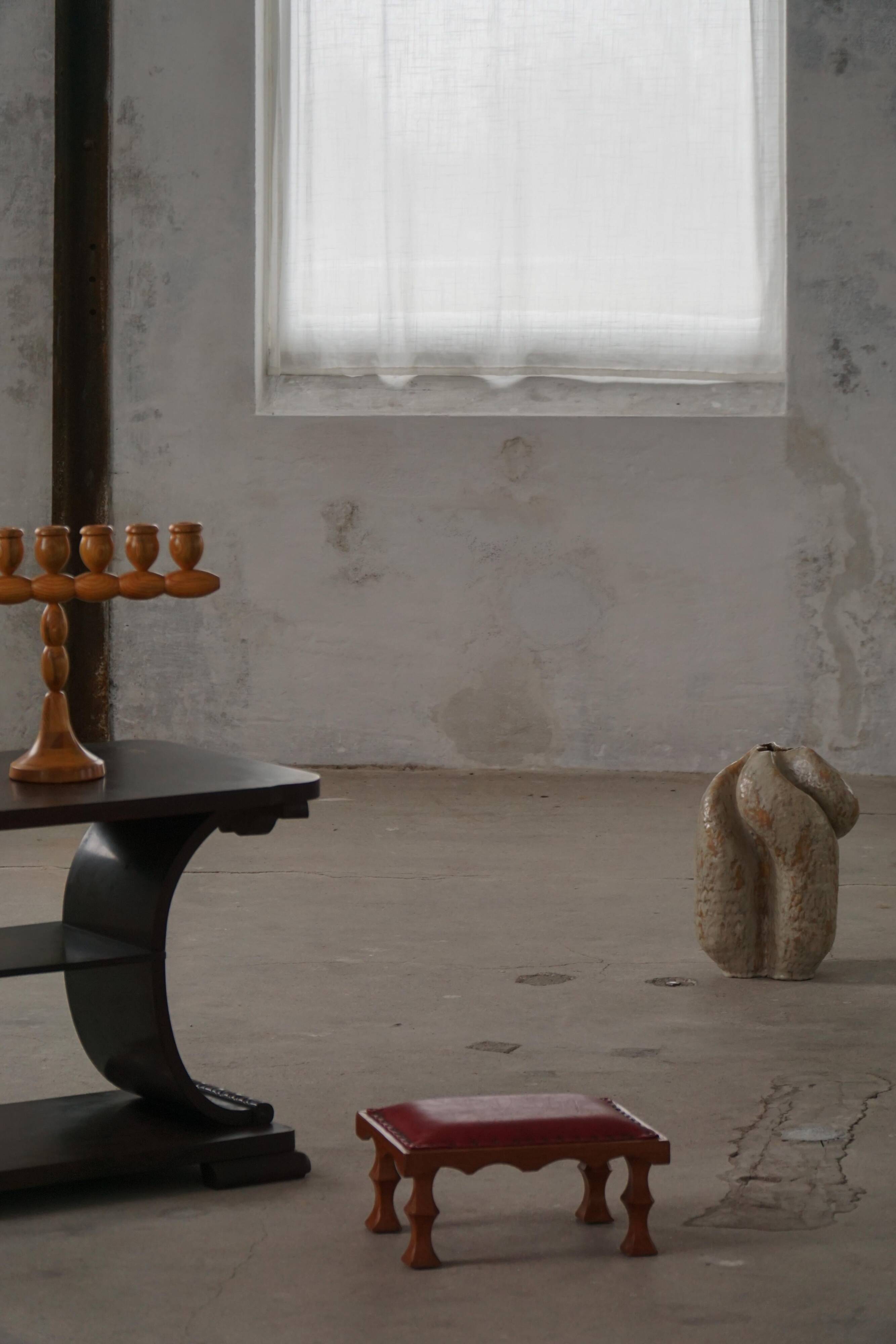 Danish sculpted oak stool from the mid-20th century with a red leather seat, 1950s.