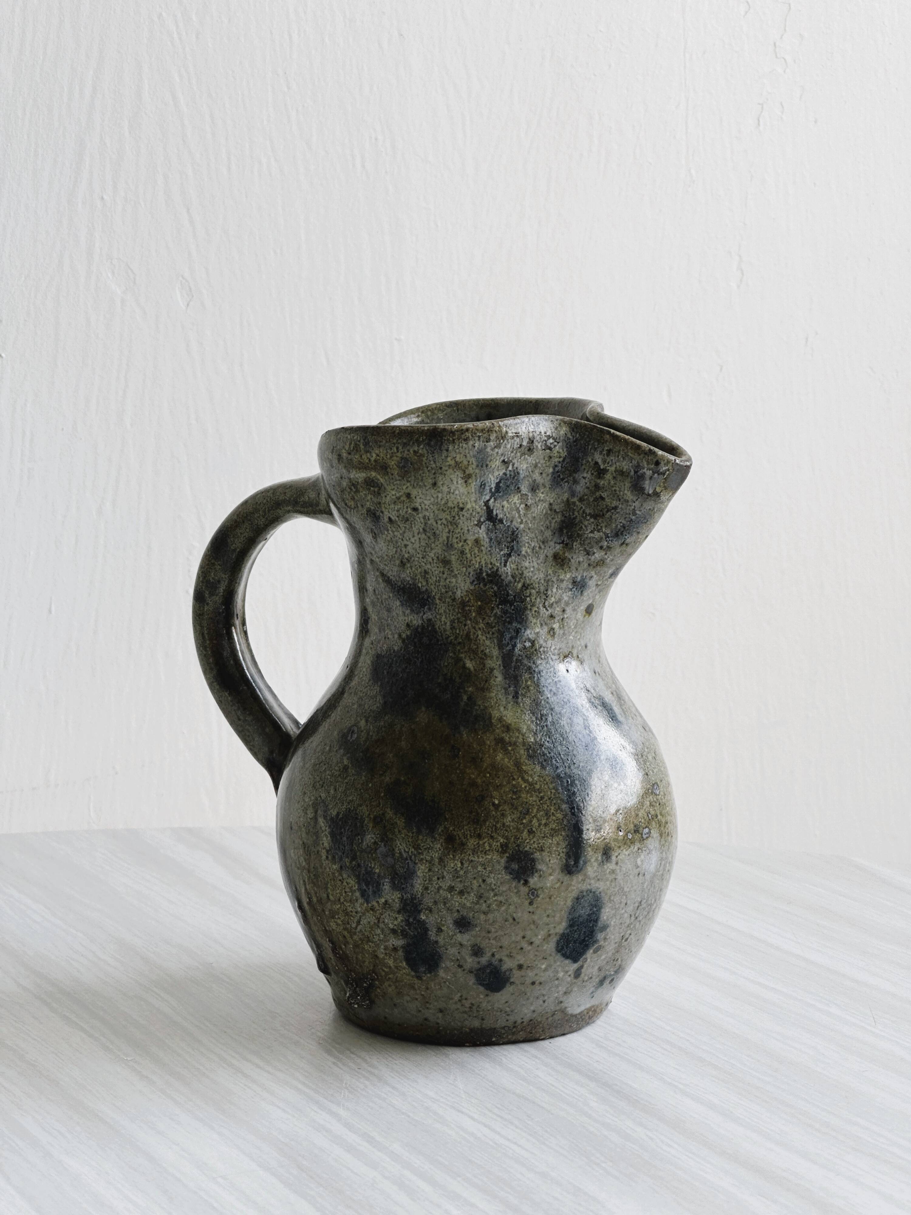 Small handcrafted ceramic pitcher with spotted enamel