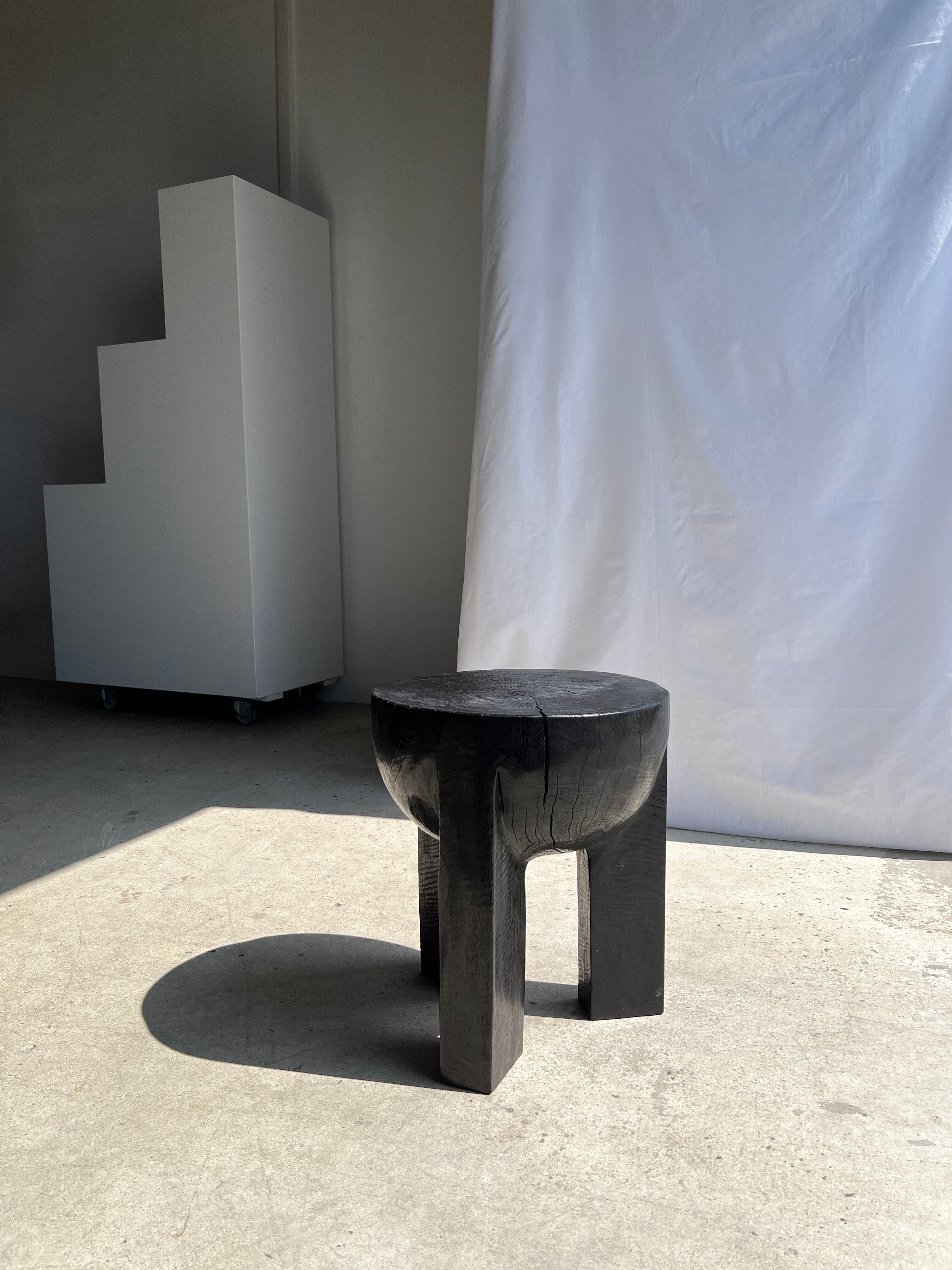 Black mango wood tripod side table with a semi-spherical top, height: 45 cm, diameter: 44 cm.