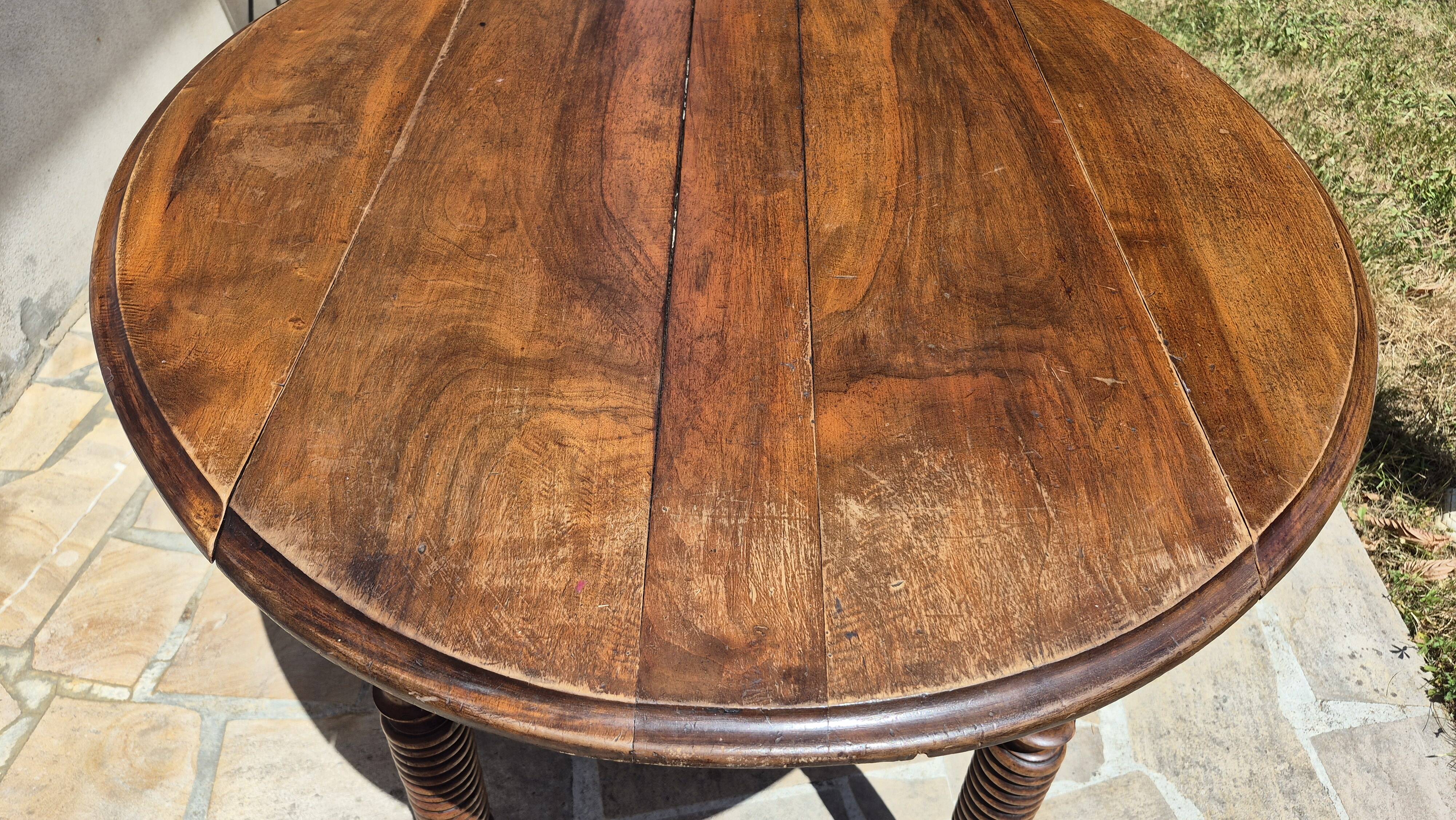 Round dining table with a drop-leaf top in solid walnut, late 19th century.