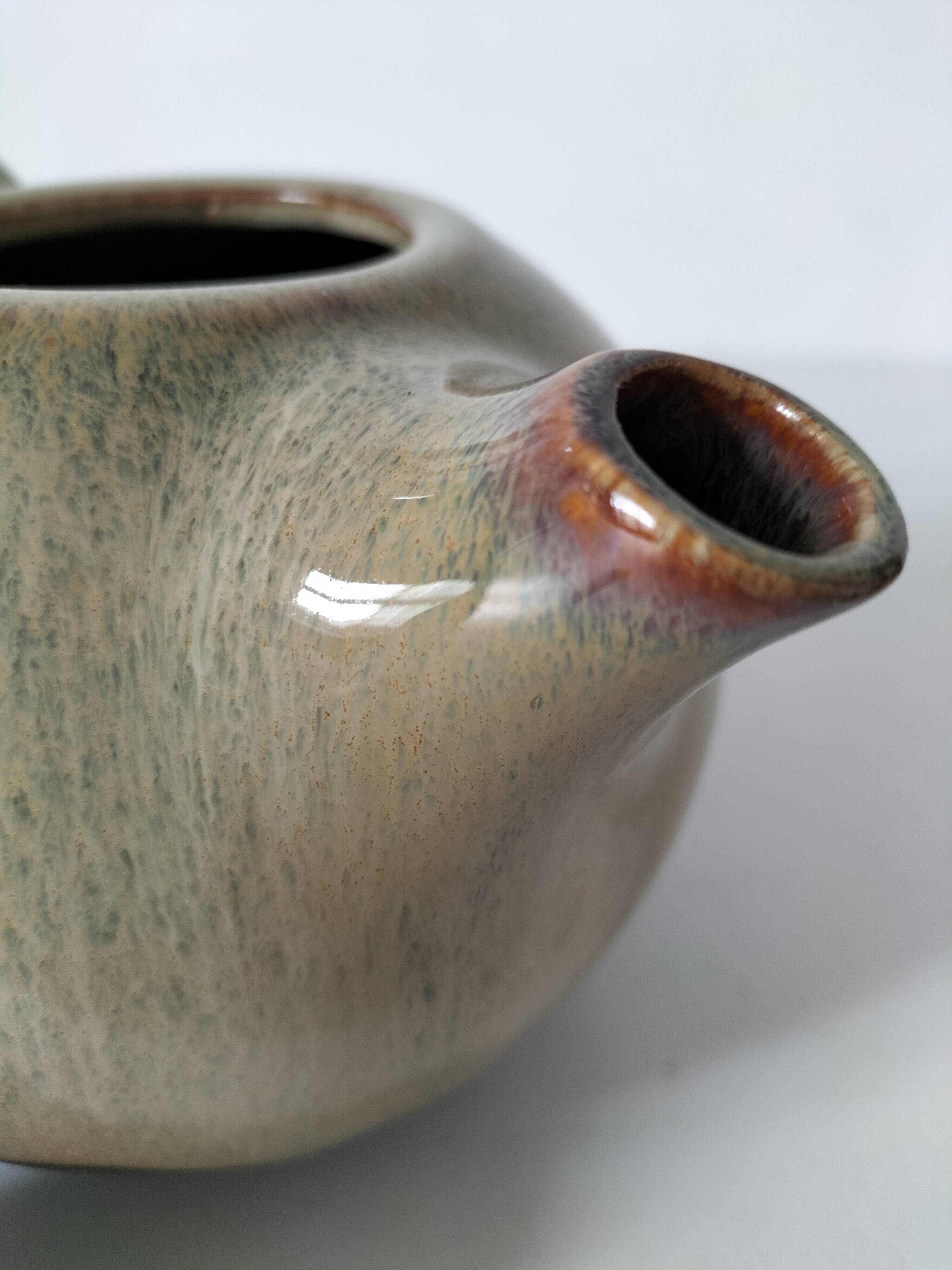 Vintage ceramic teapot with a flame design.
