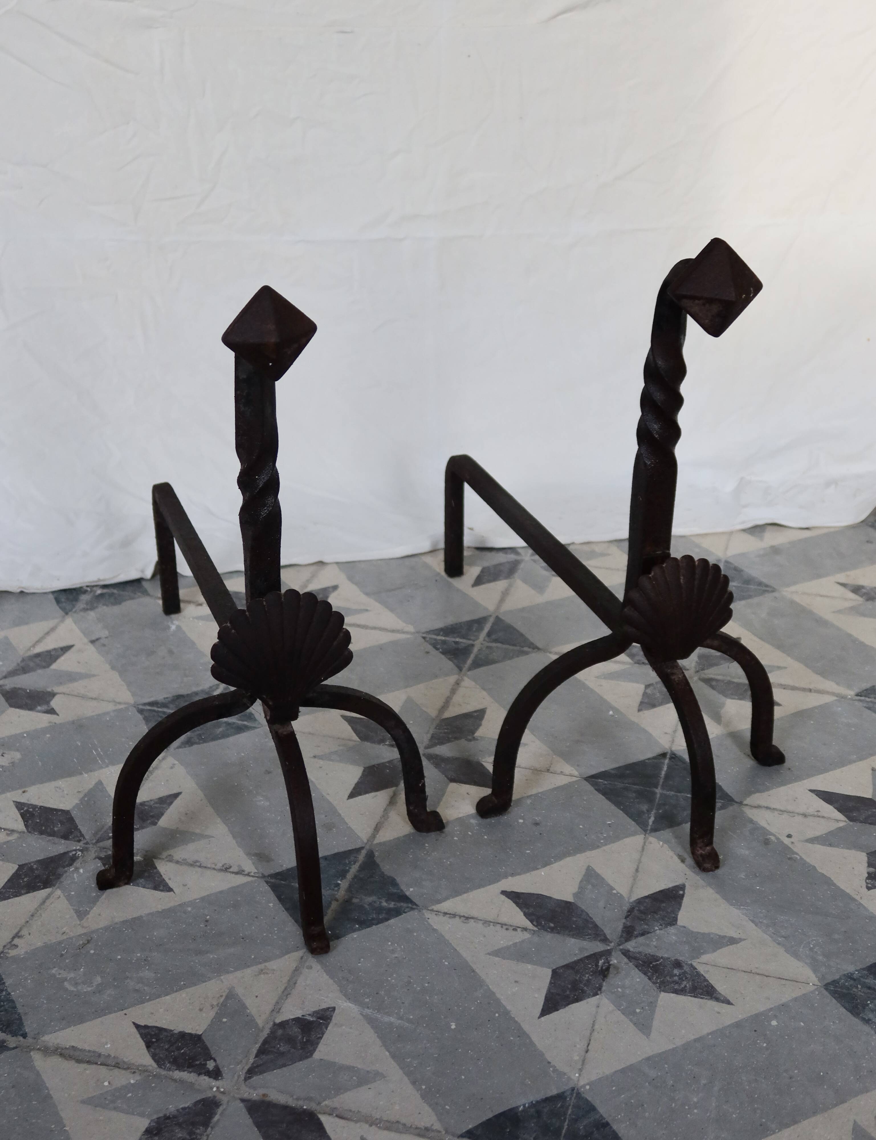 Vintage metal and cast iron fire dogs with shell motif.