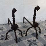 Vintage metal and cast iron fire dogs with shell motif.