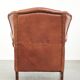 Fauteuil anglais à oreilles de couleur cognac clair en cuir de vache.