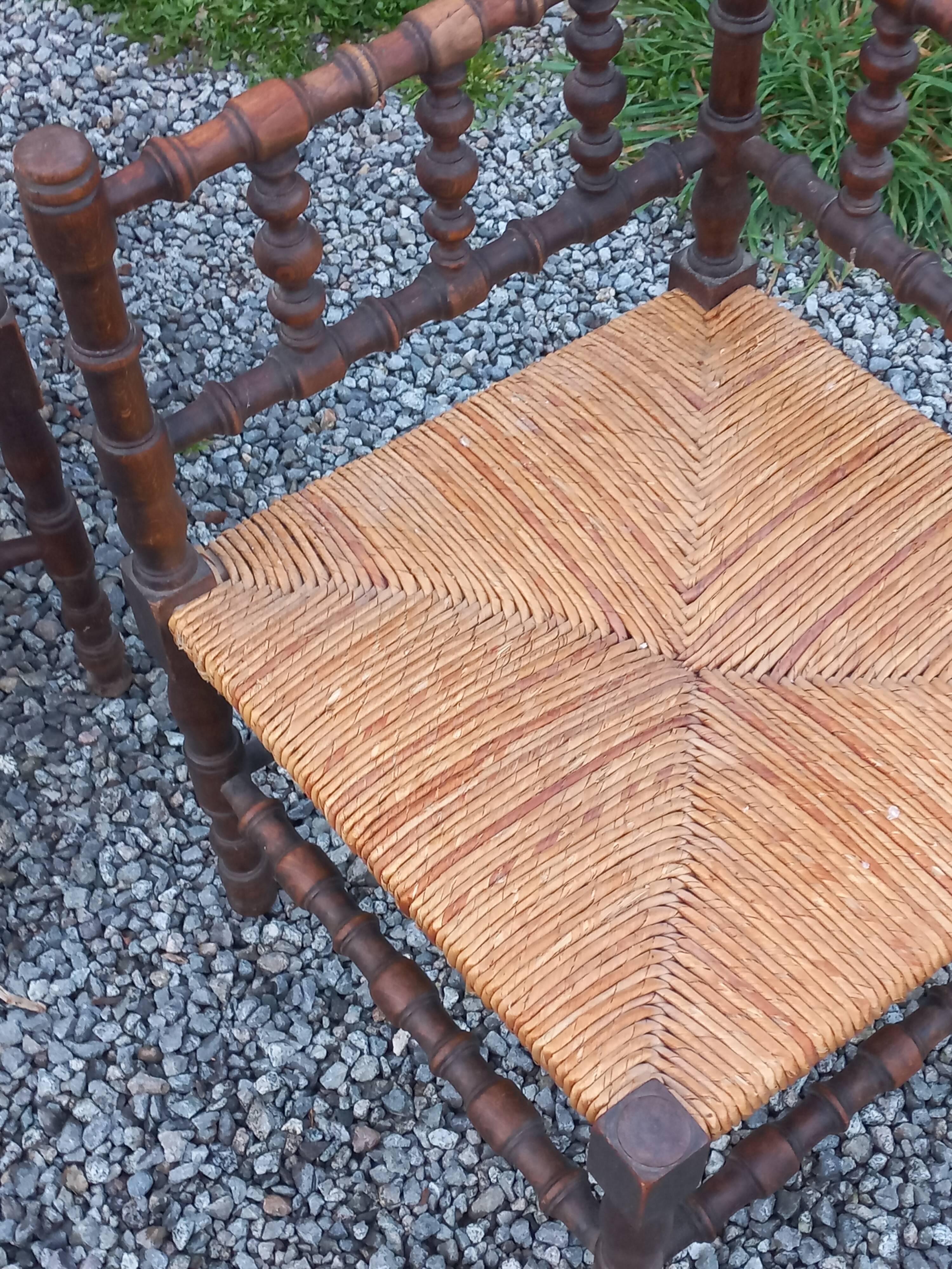 Pair of angled armchairs with turned wood and rush seats from the 1960s.