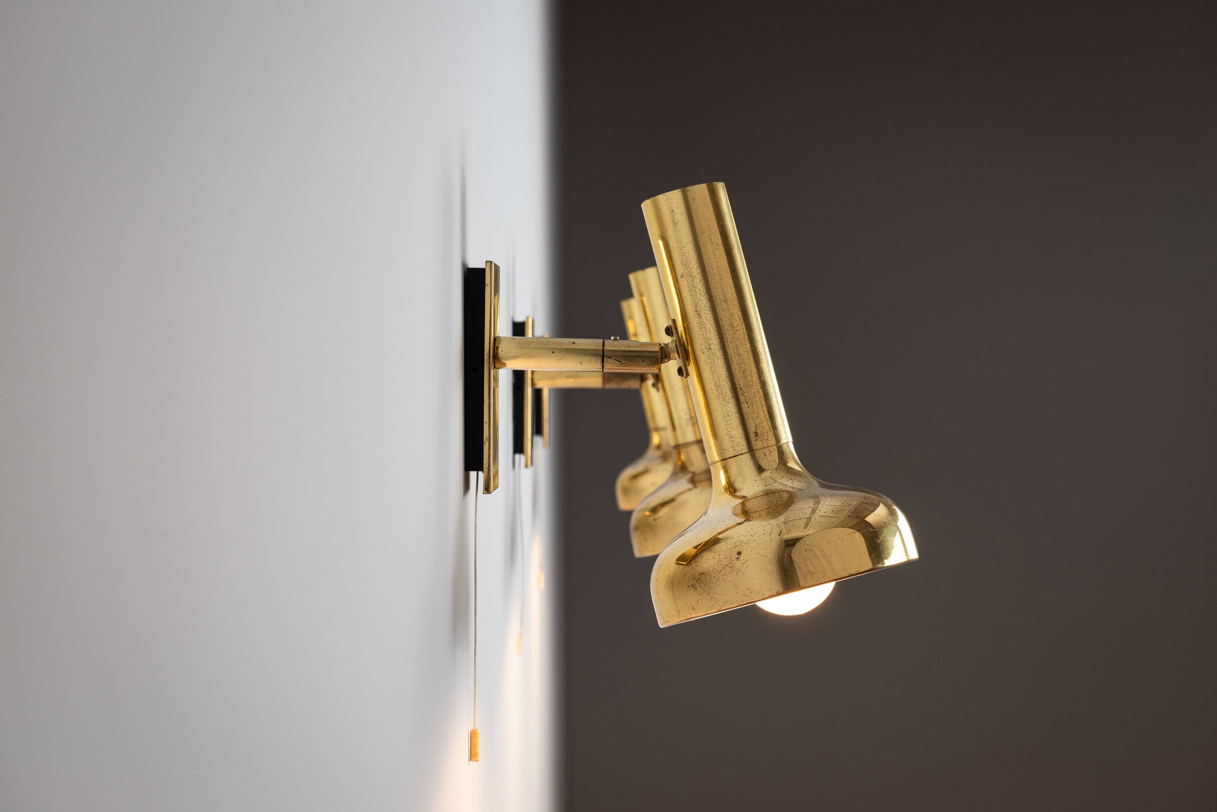 Set of three brass adjustable wall lamps