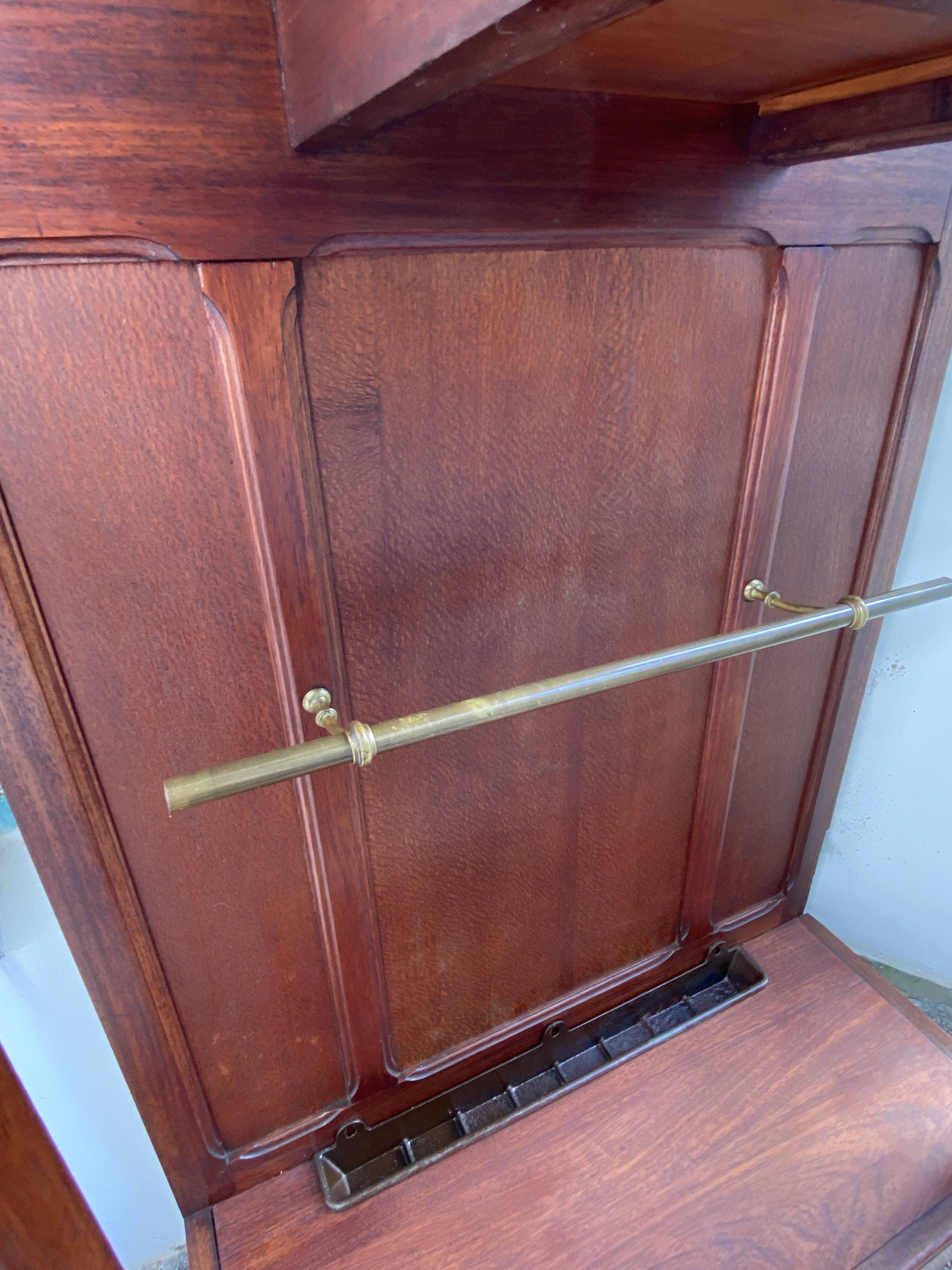 Antique wooden coat rack with mirror and shelf.