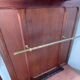 Antique wooden coat rack with mirror and shelf.