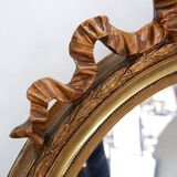 Wear consistent with age and use Wood and gilded plaster "Noeud d'Amour" Oval mirror
