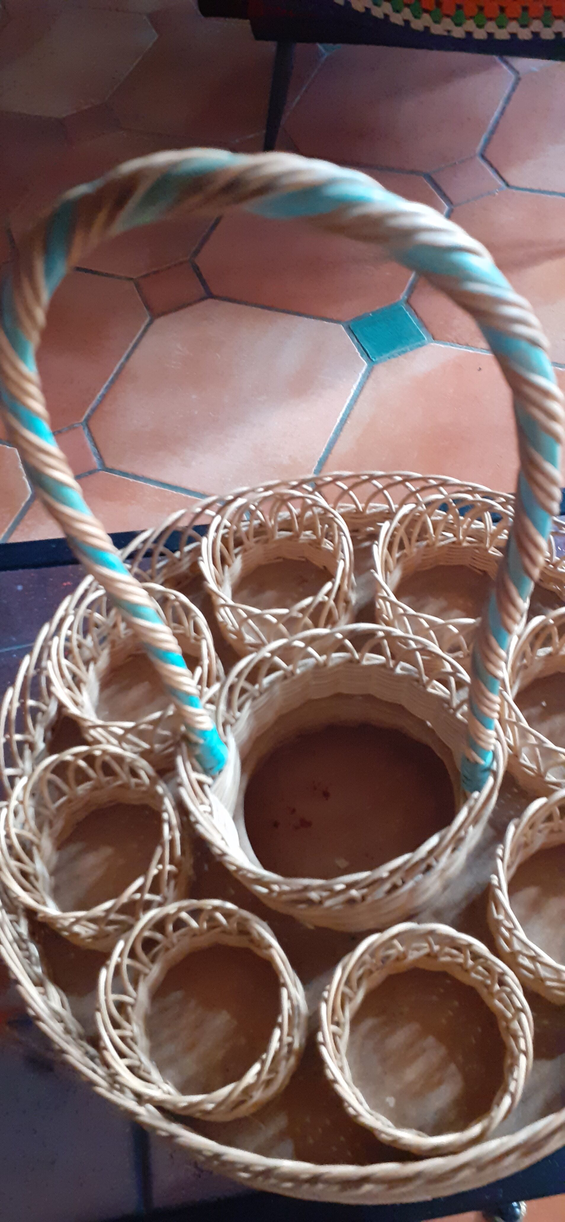 Glass holder and wicker bottle with green plastic water surface