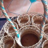 Glass holder and wicker bottle with green plastic water surface