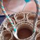 Glass holder and wicker bottle with green plastic water surface