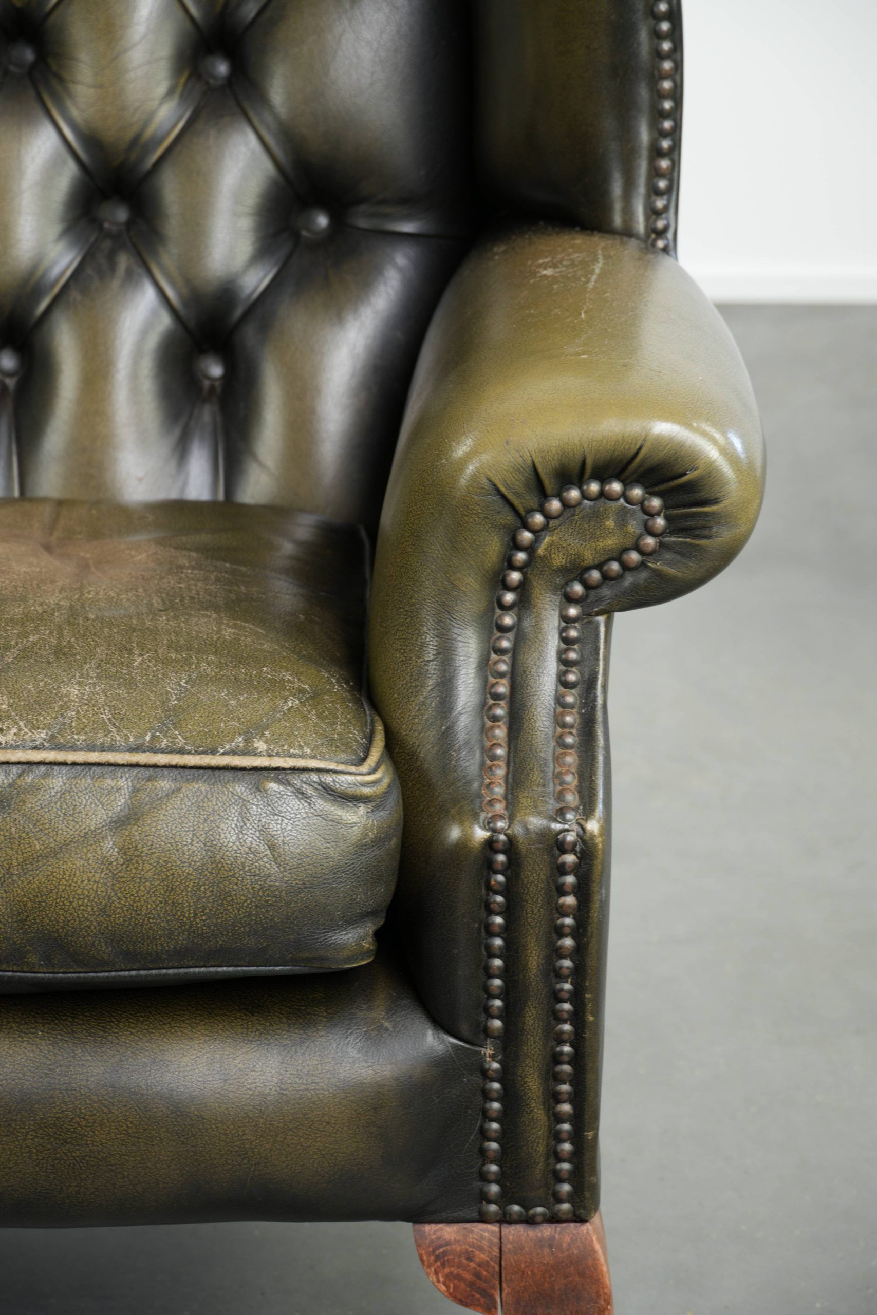 Vintage cowhide leather Chesterfield wingback armchair in a green colour