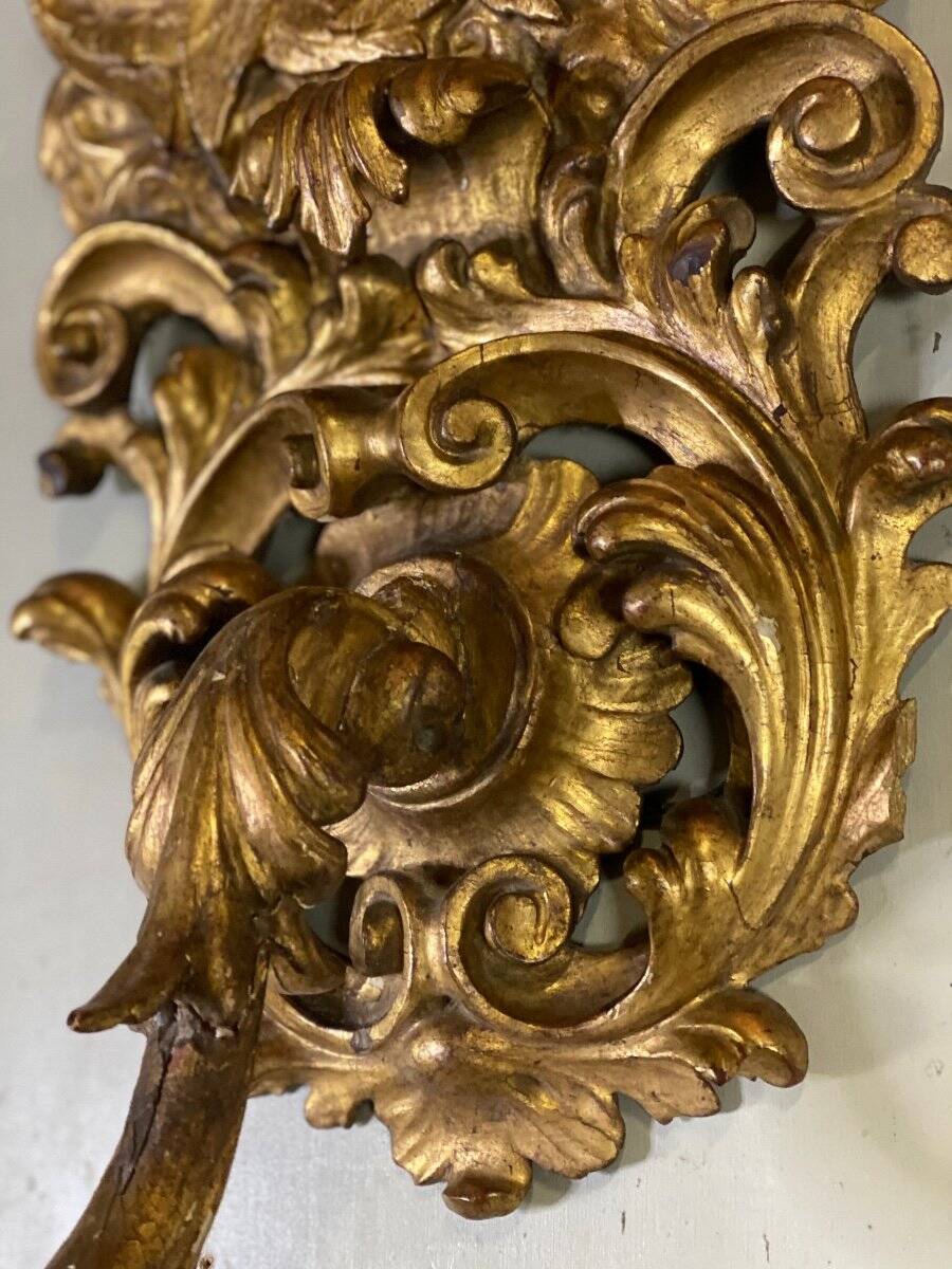 Paire d’appliques en bois sculpté et doré surmontées de deux têtes d’angelots, Italie