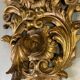 Paire d’appliques en bois sculpté et doré surmontées de deux têtes d’angelots, Italie