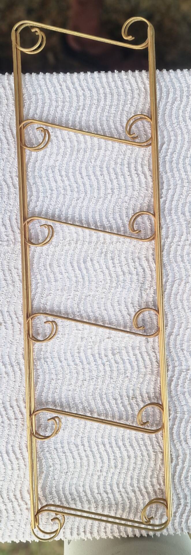 Wall shelf in metal with slanted shelves