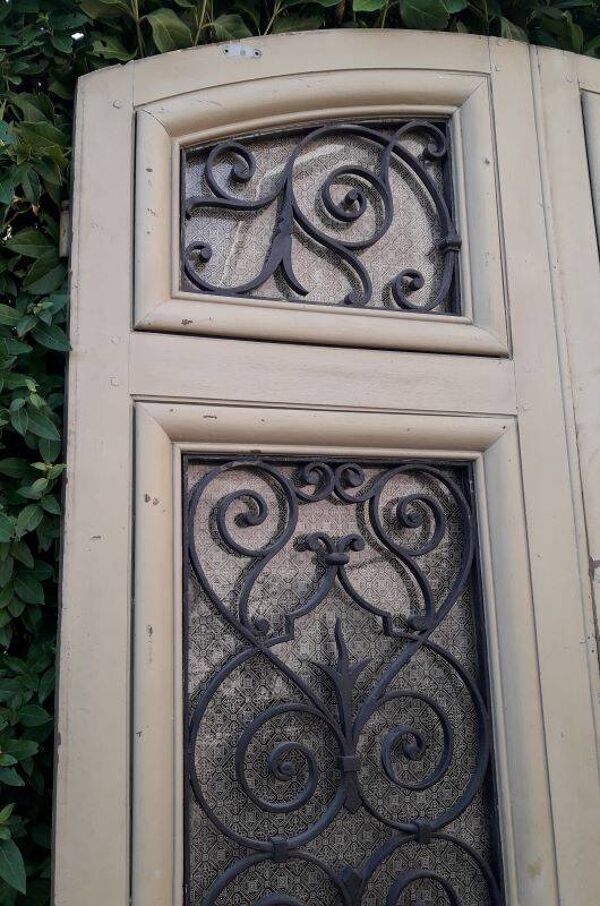 Porte d'entrée cintrée double en chêne, grilles et verre, XIXème