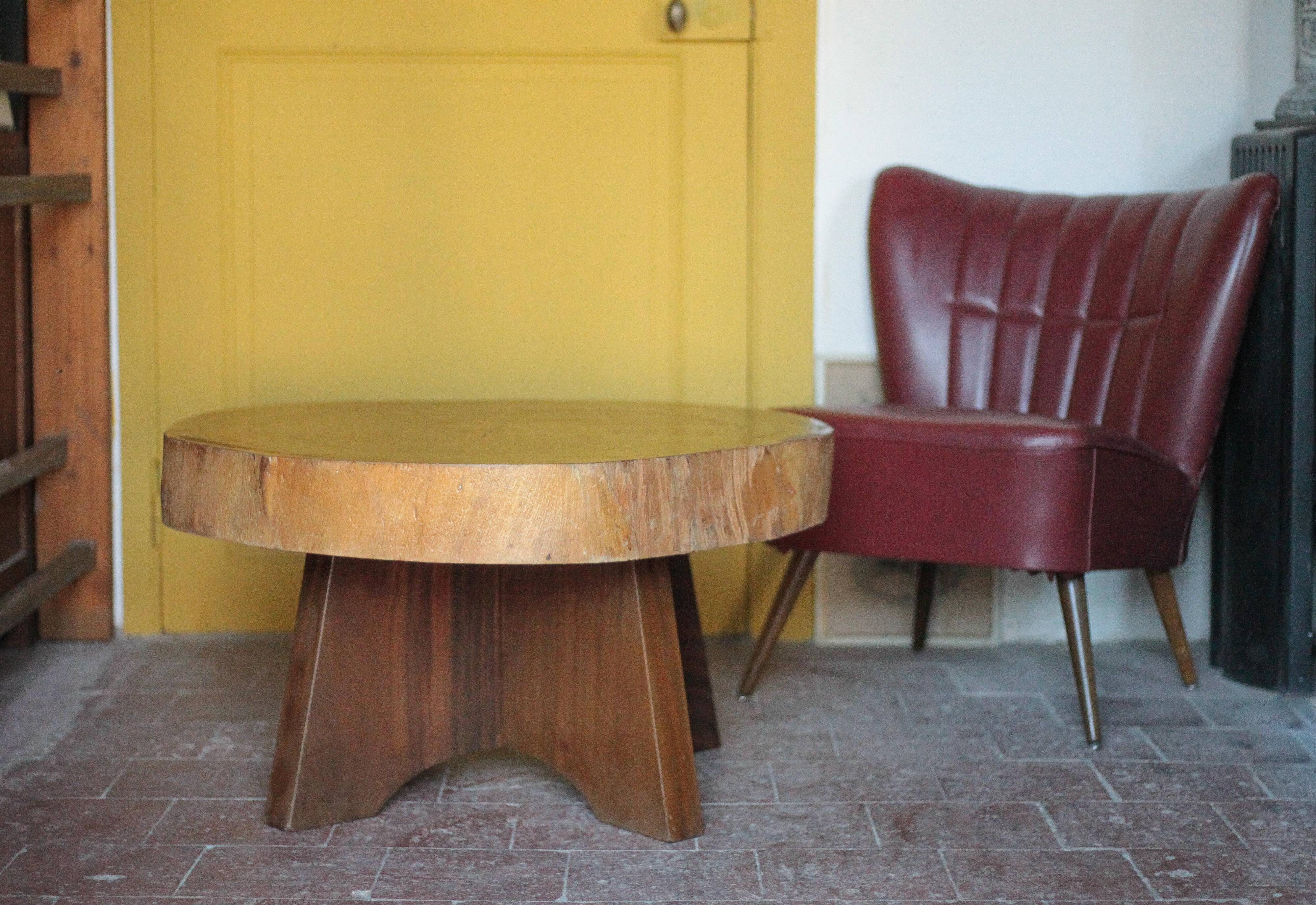 Brutalist wooden coffee table, cruciform leg with a tree trunk top.