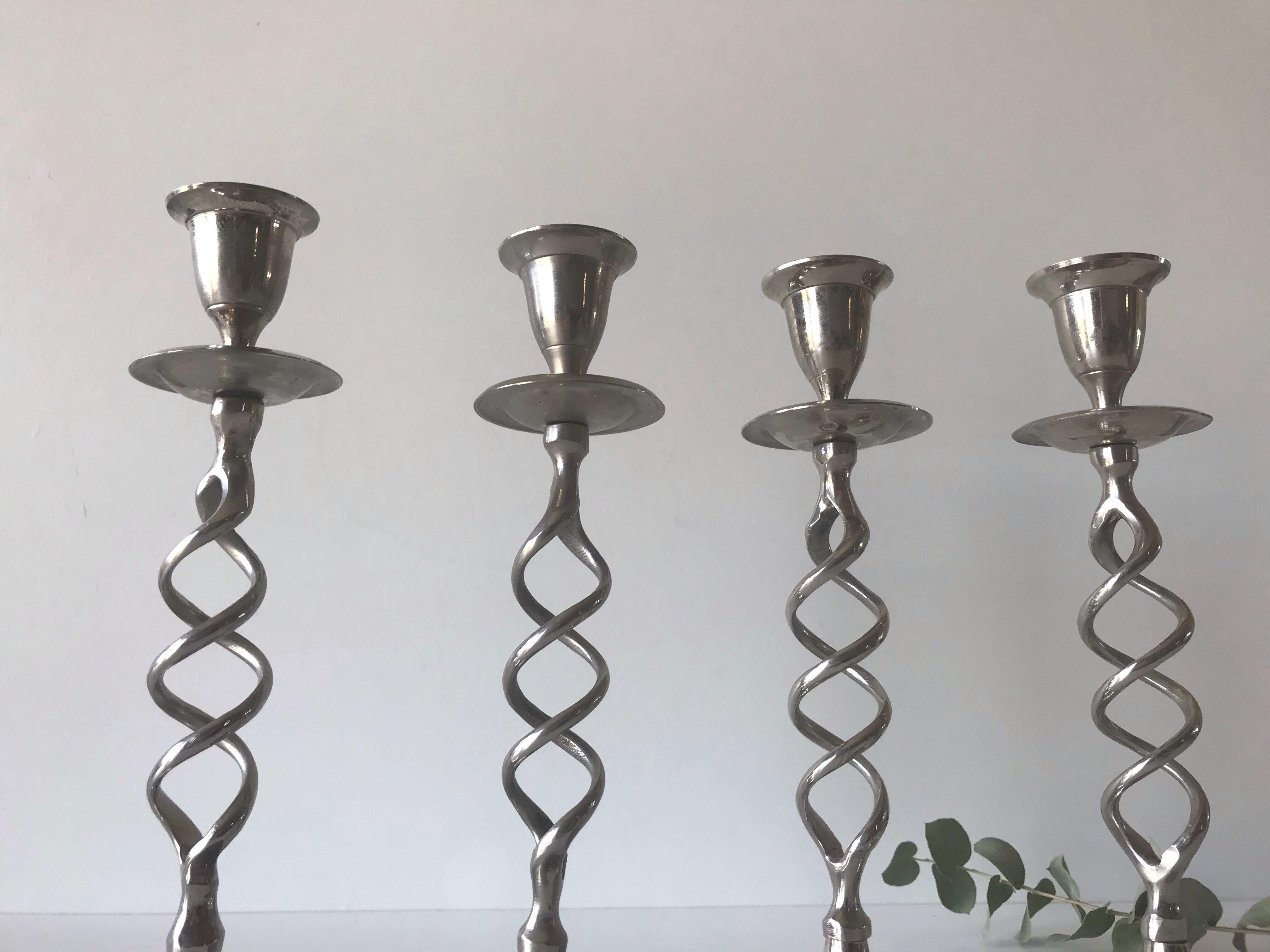 Four twisted silver candlesticks