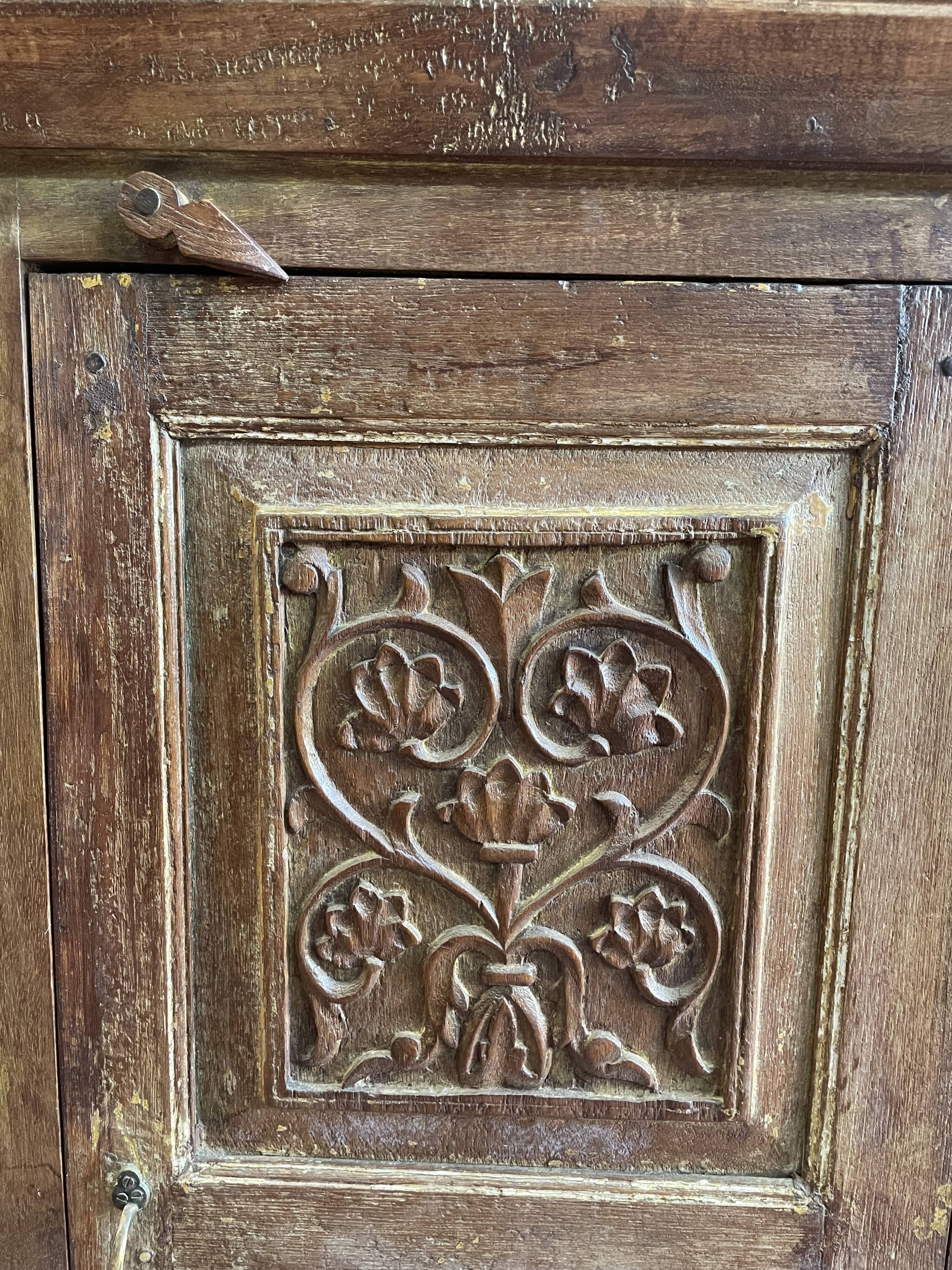 India. Bonnetière with a teak door finely carved by hand.
