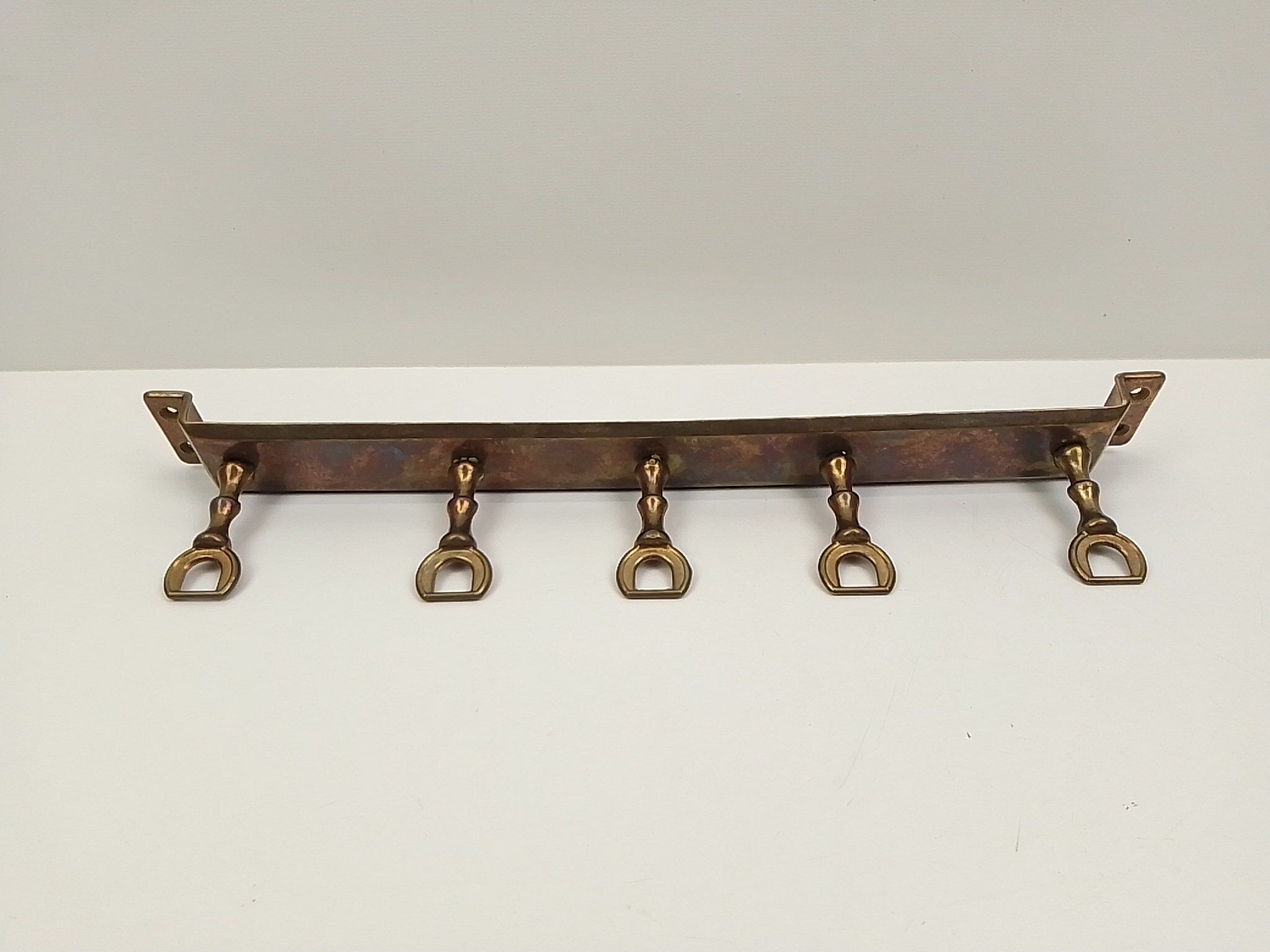 5 kitchen utensils and a brass wall mount