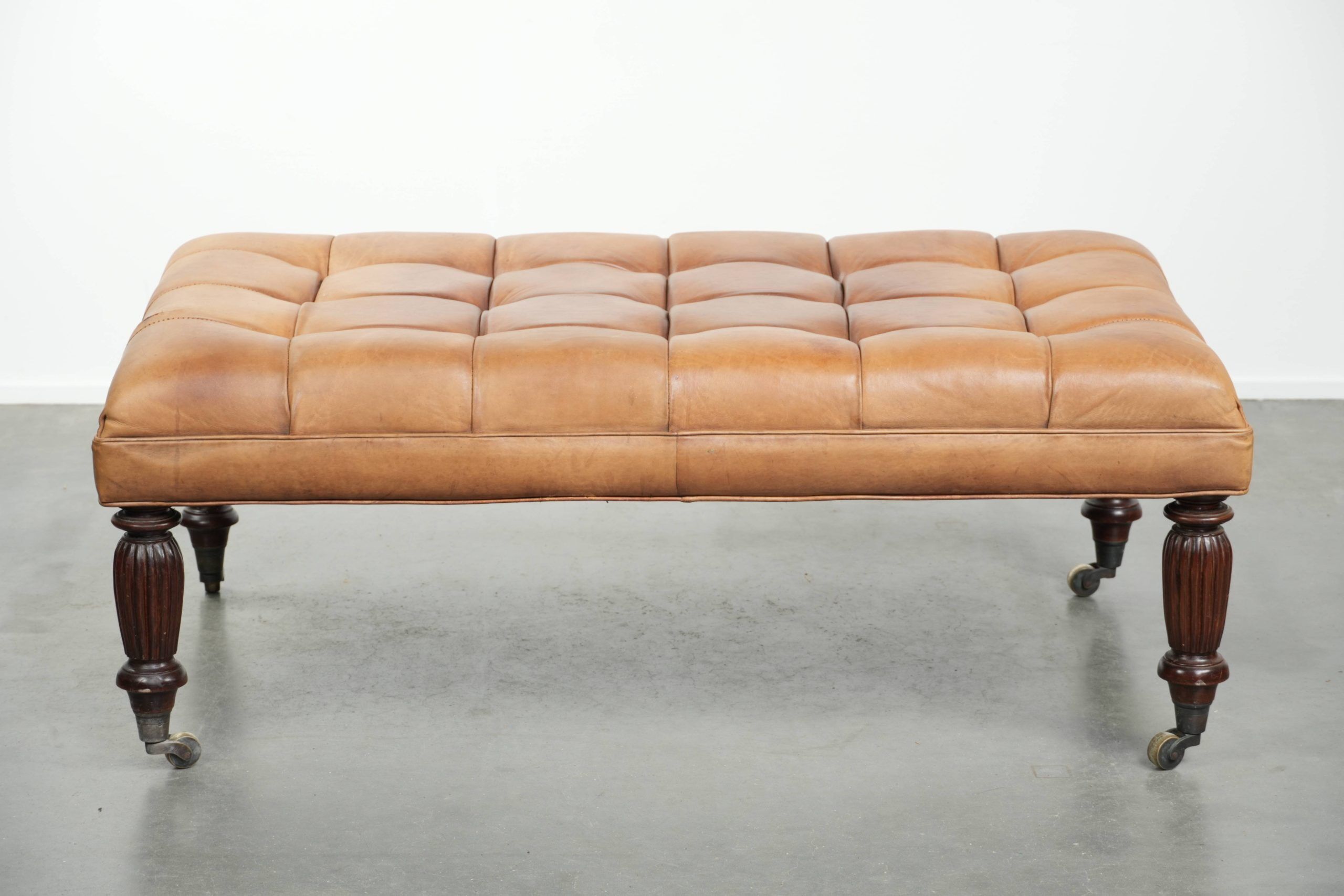 Sheepskin ottoman/coffee table on wheels in English chesterfield style
