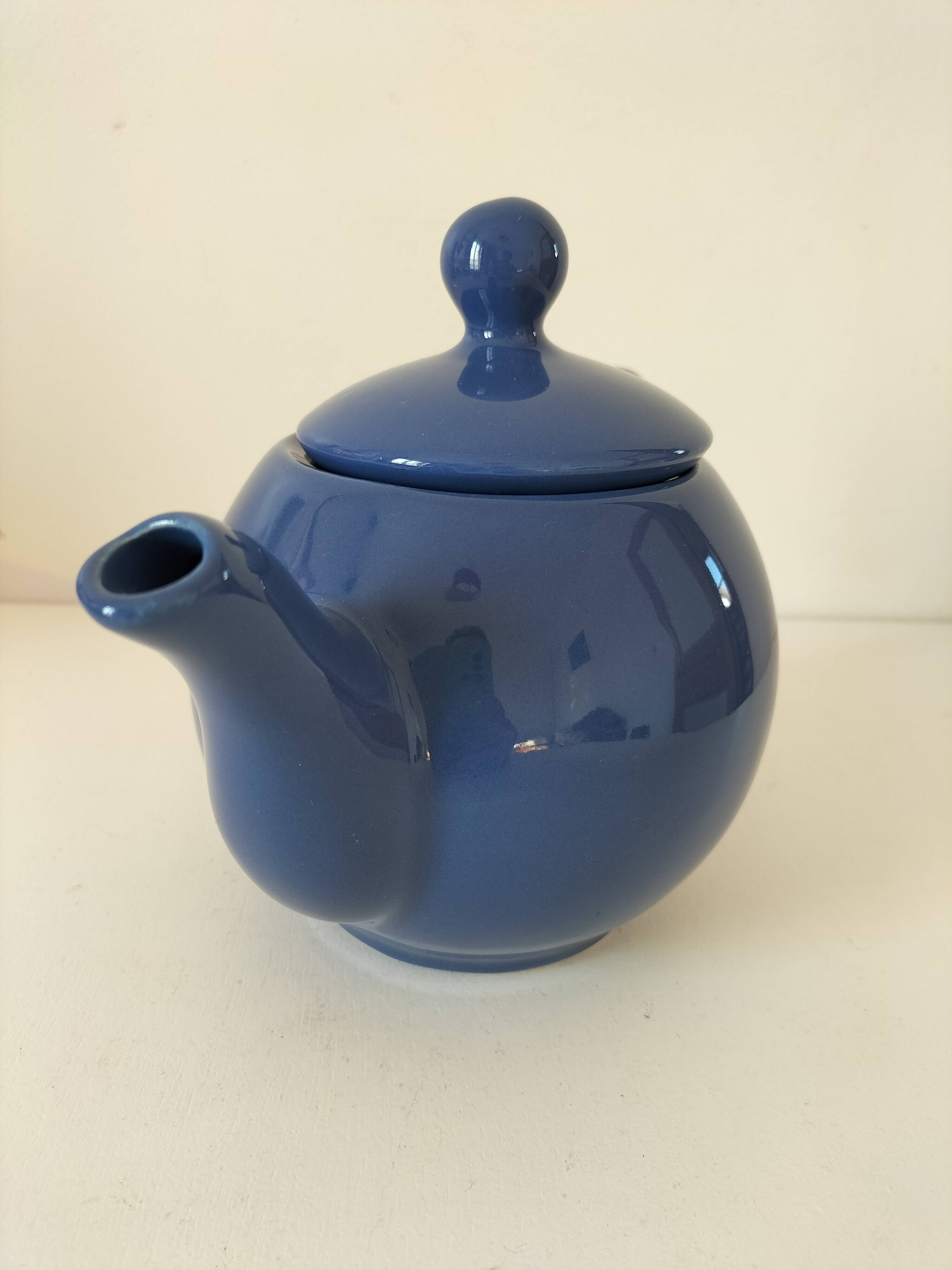 Vintage deep blue teapot, minimalist round shape.