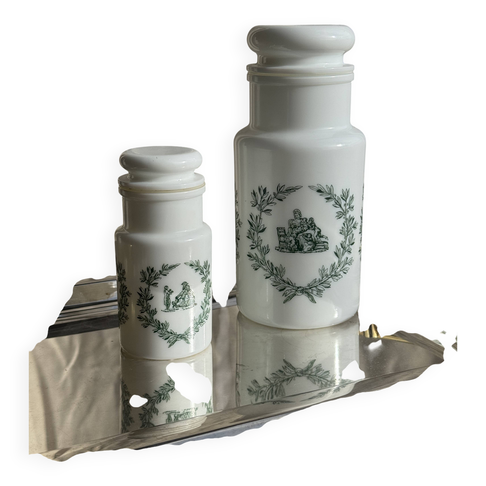 A pair of white glass bottles with Italian green patterns.