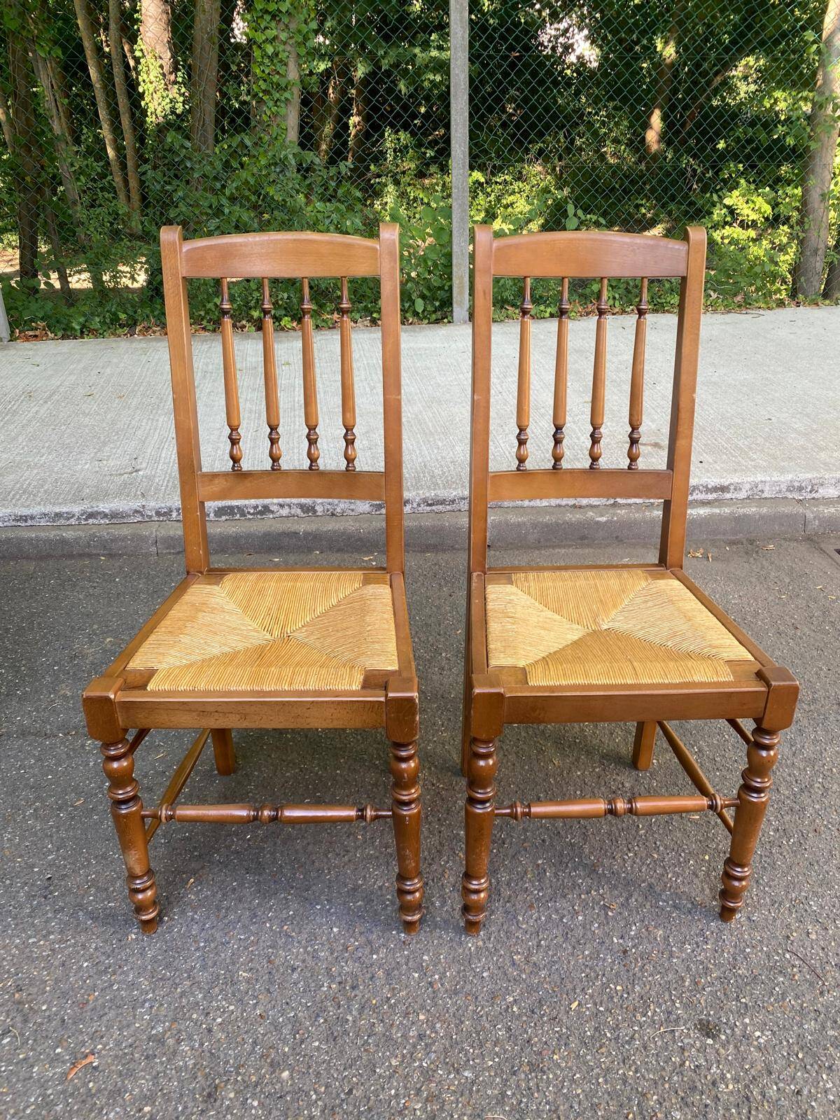 Solid wood chair with a straw seat and carved bar backrest.