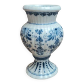 Small vintage vase in blue and white Delft style on a pedestal.