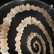 Round coffee table with double glass top, spiral carved decoration.