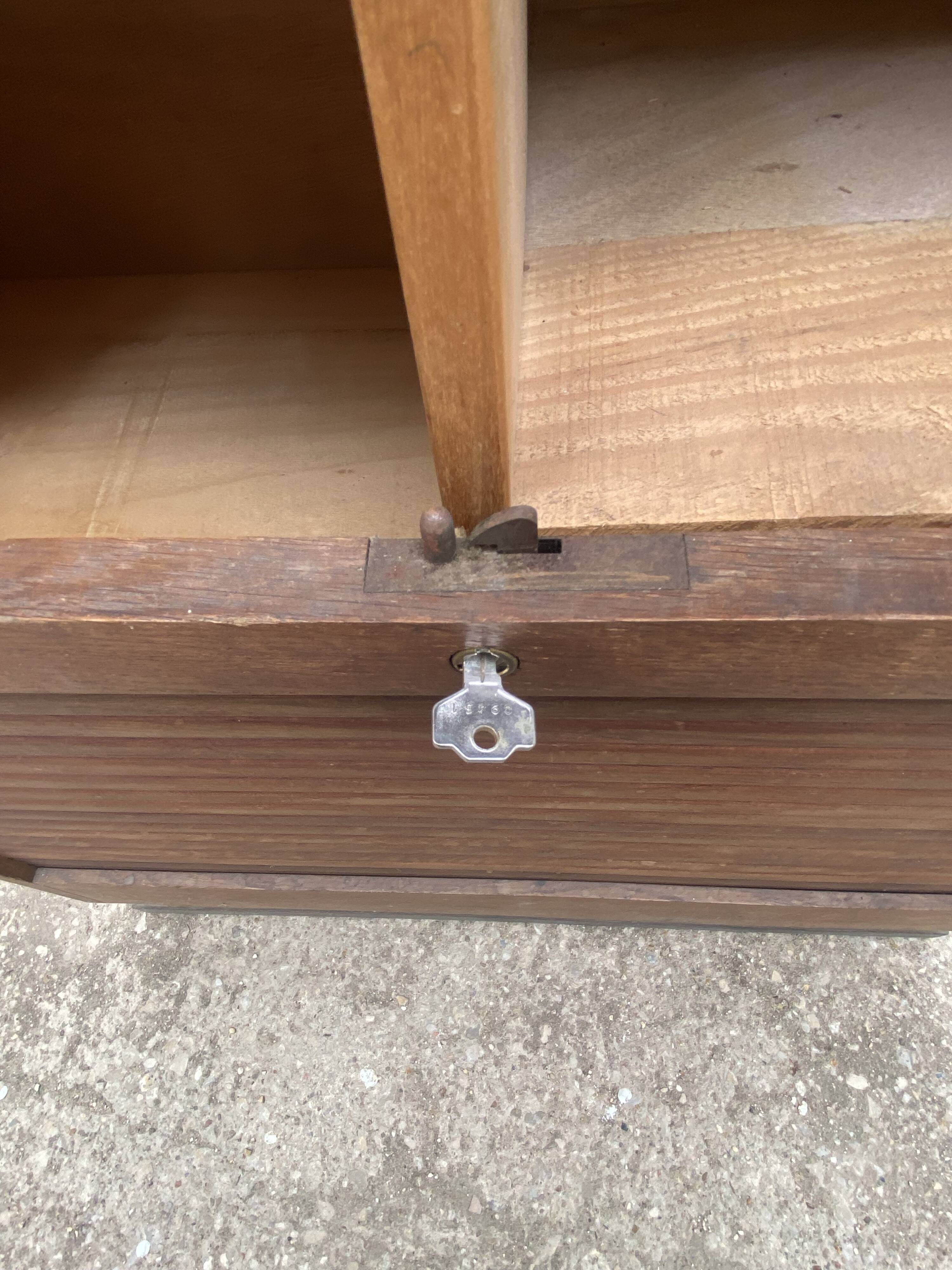 Oak two-column filing cabinet with curtains.
