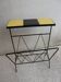 Black metal magazine rack and yellow and black tiled shelf.