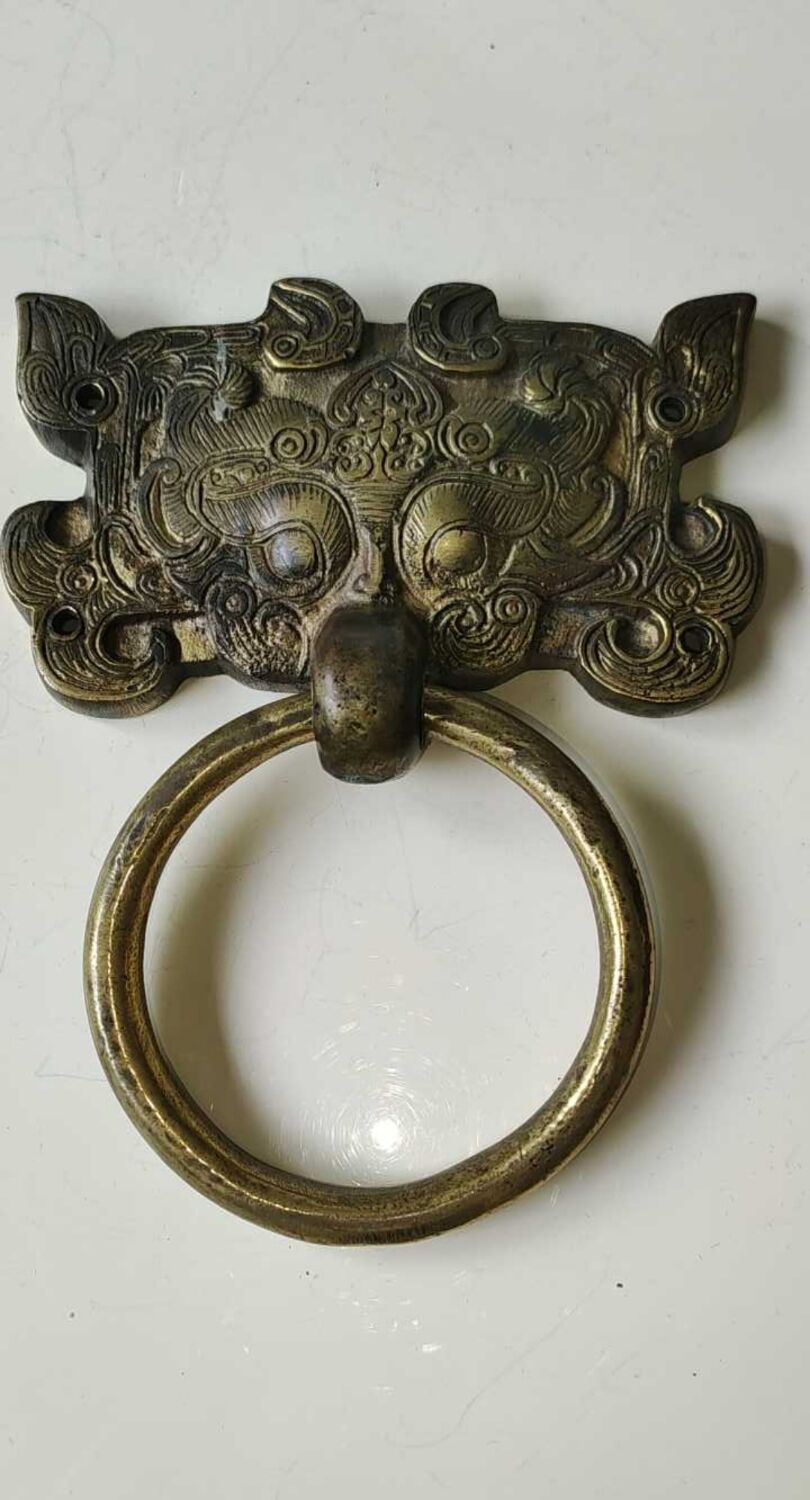 Ancient door knocker, taotié mask, shang dynasty. in bronze golden patina