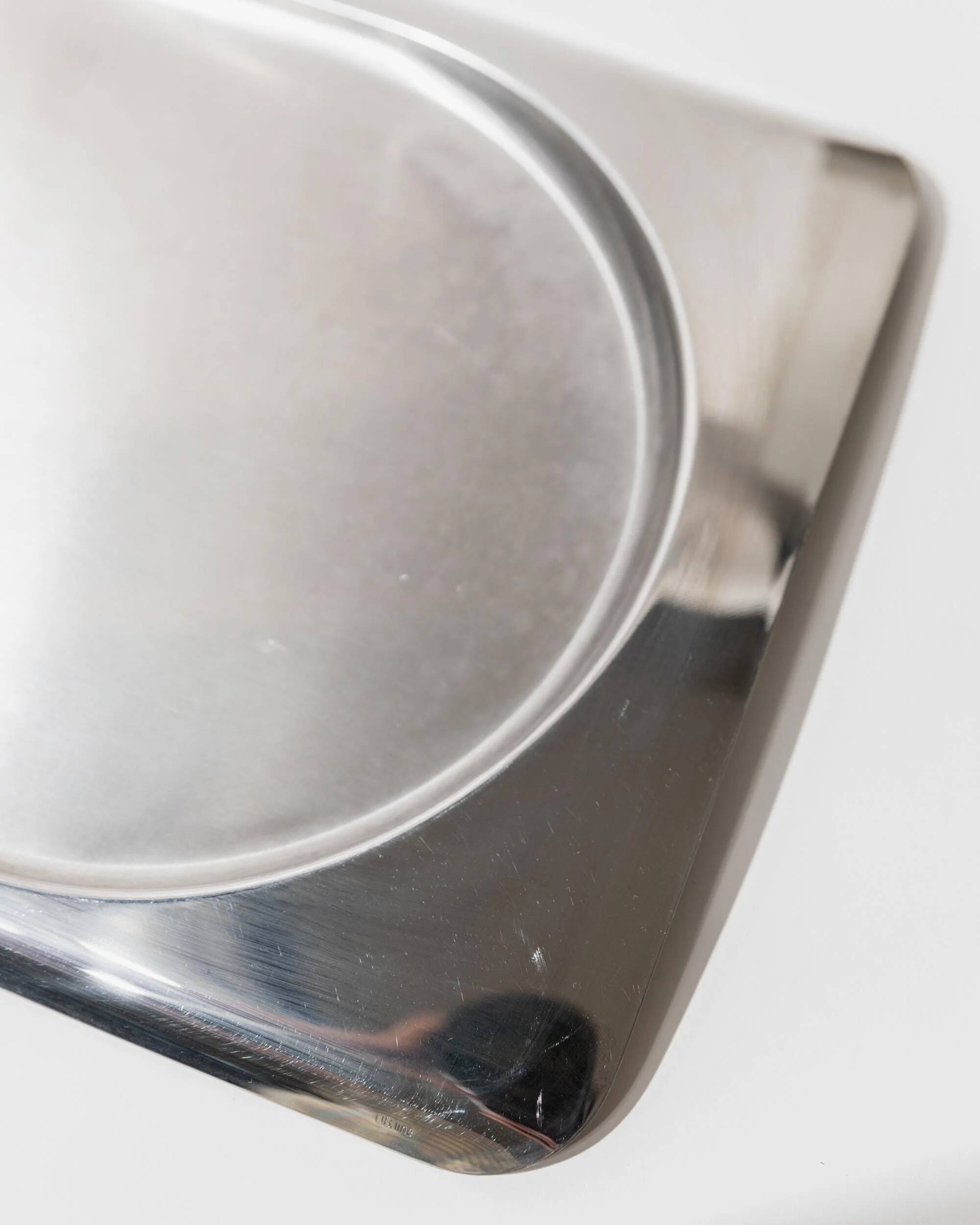 1990s vintage stainless steel platter, rectangular with an oval indentation, minimalist modern design.
