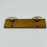 Vintage wall coat rack in brass and wood design.
