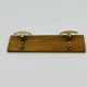 Vintage wall coat rack in brass and wood design.