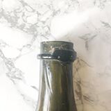 Old rum bottle in thick puffed glass in dark green color