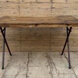 Folding workshop table with a metal frame and solid teak top.