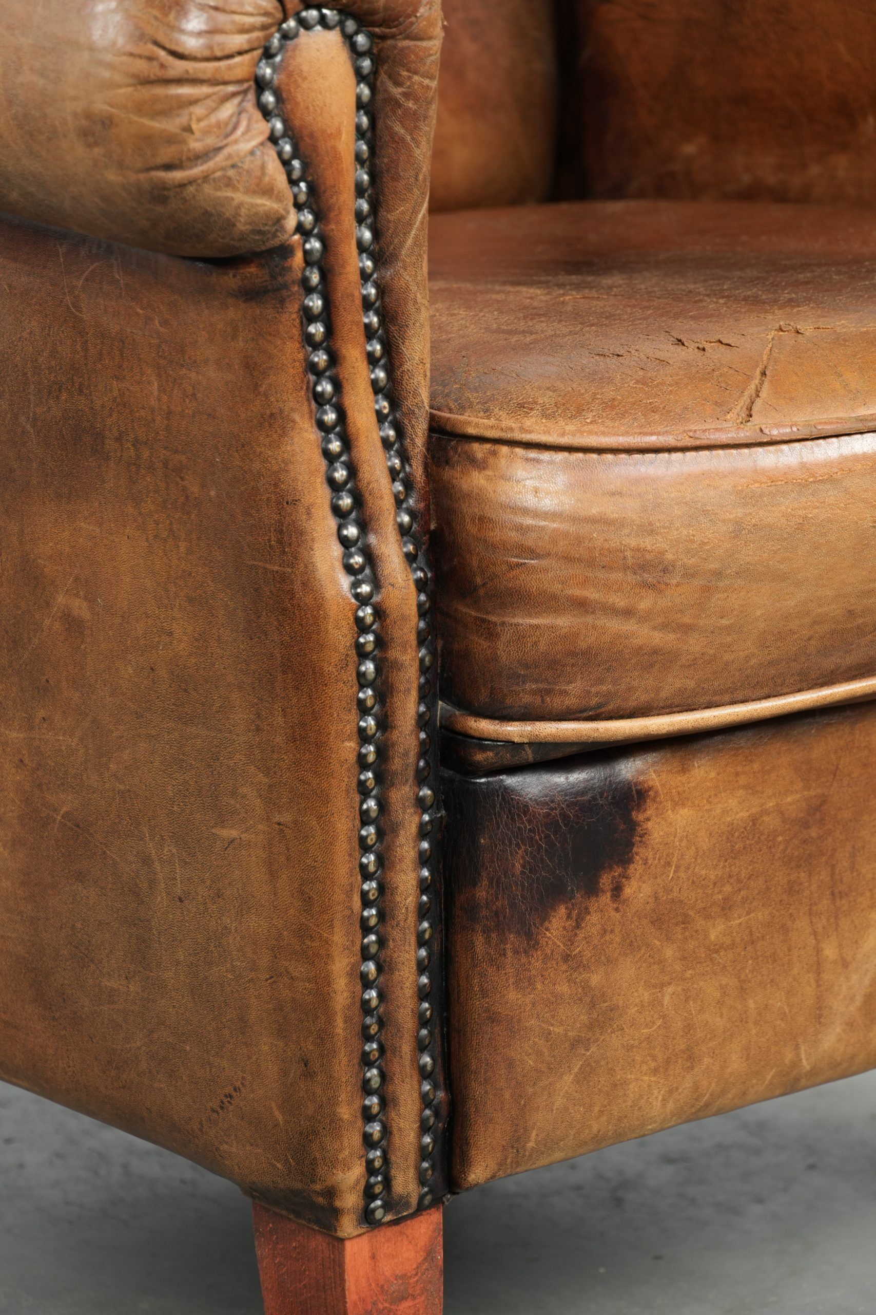 Sheepskin armchair with a beautiful vintage look and decorative nail finish