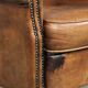 Sheepskin armchair with a beautiful vintage look and decorative nail finish