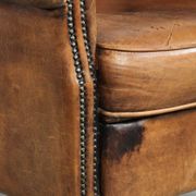 Sheepskin armchair with a beautiful vintage look and decorative nail finish