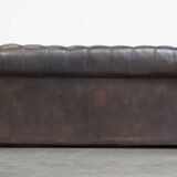 Old dark brown 3-seater cowhide chesterfield sofa with lots of character