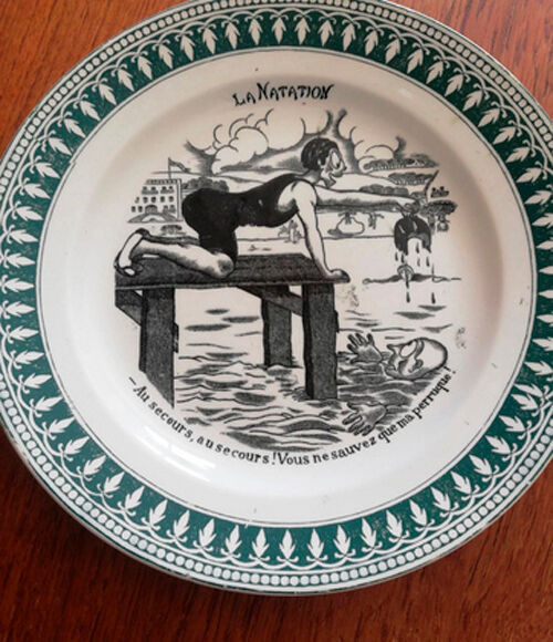 Old vintage dessert plate with drawing and phrase "swimming"
