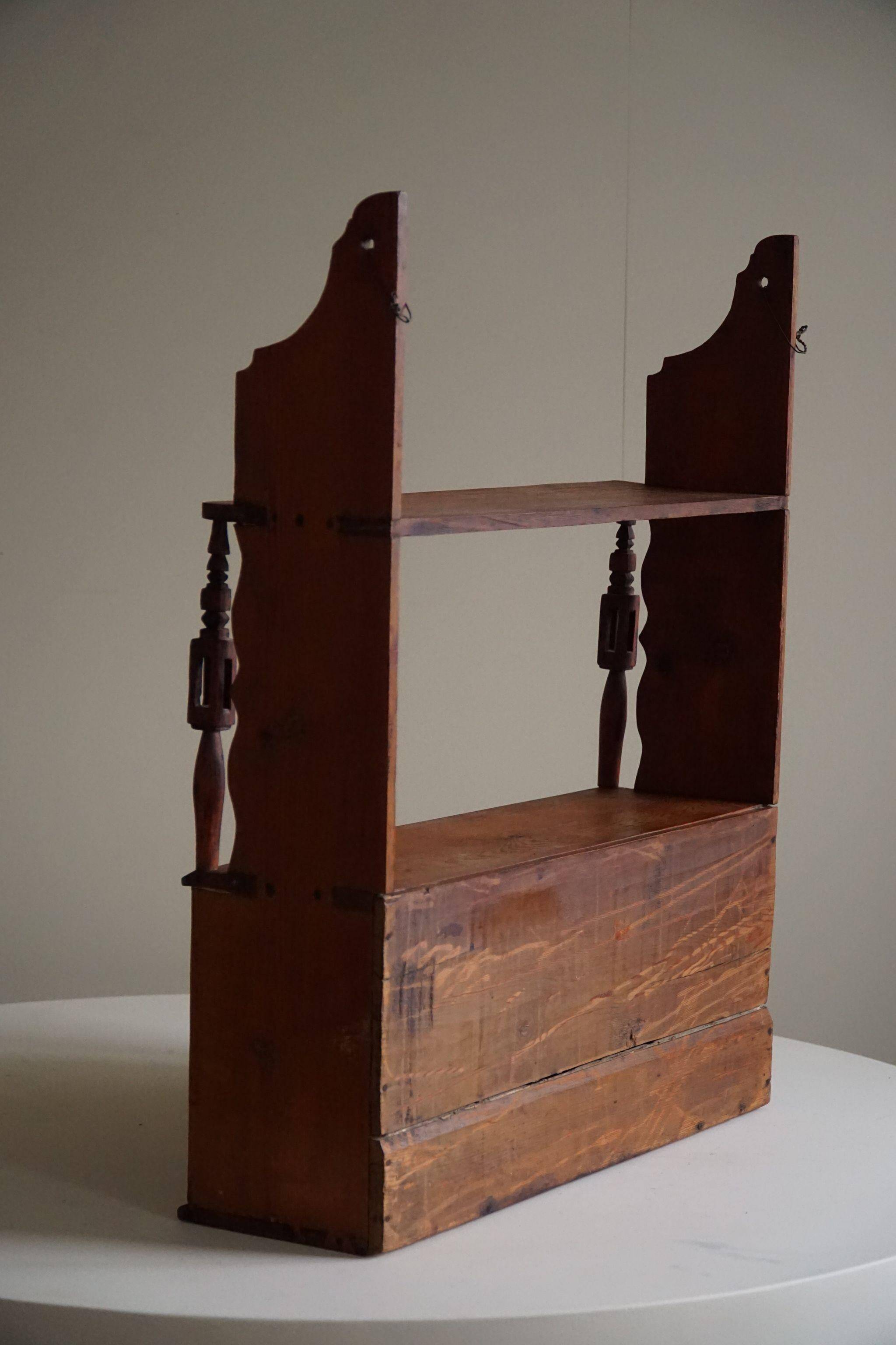 Primitive wall shelf in pine, by a Swedish upholsterer, late 19th century.