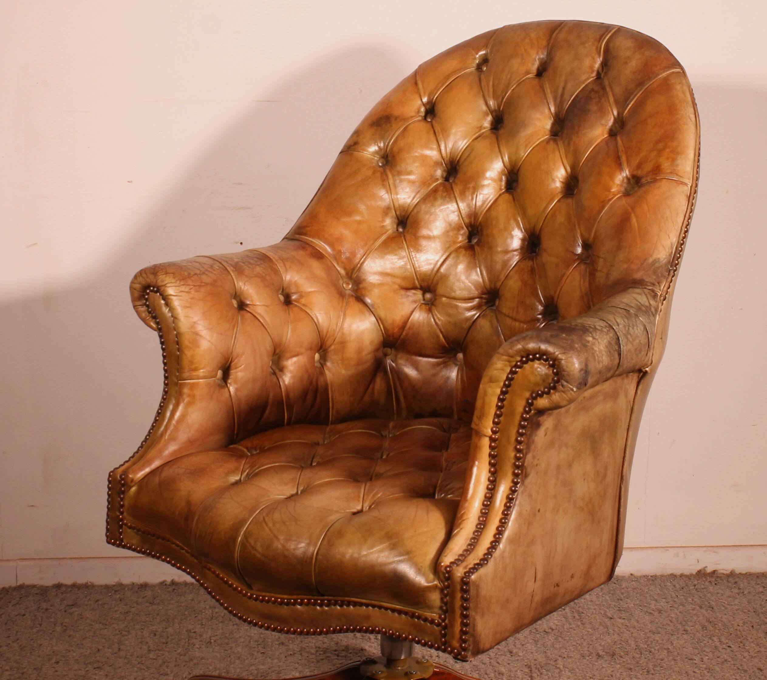Office chair known as a presidential chair in mahogany and cognac leather.