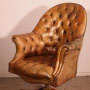 Office chair known as a presidential chair in mahogany and cognac leather.
