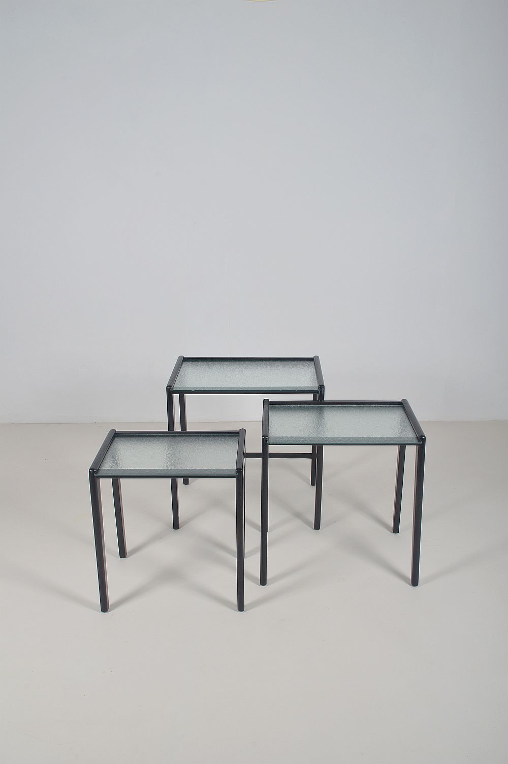 Tables gigognes en bois teinté noir et plateau en verre, années 1960